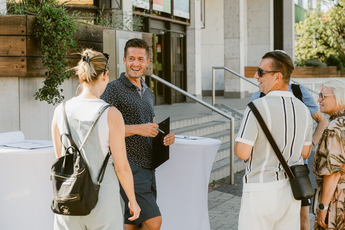 Roman Krištofík so skupinou ľudí pri stolíku pred kultúrnym domom